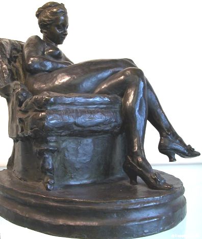 Femme nue lisant dans un fauteuil